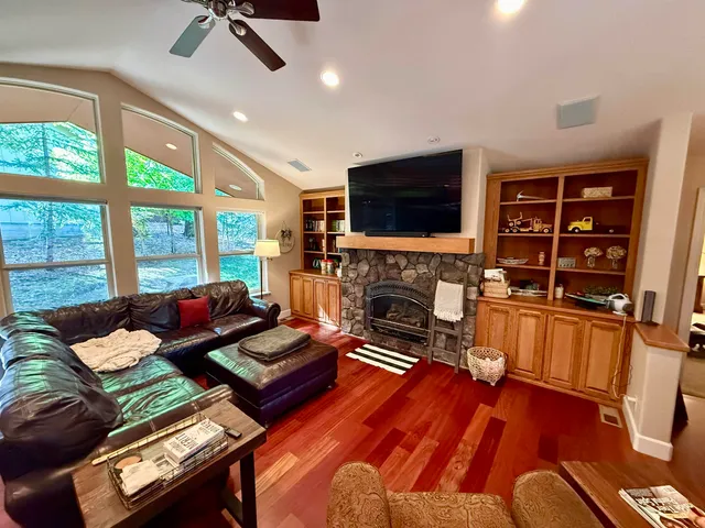 a living room with furniture a flat screen tv and a fireplace