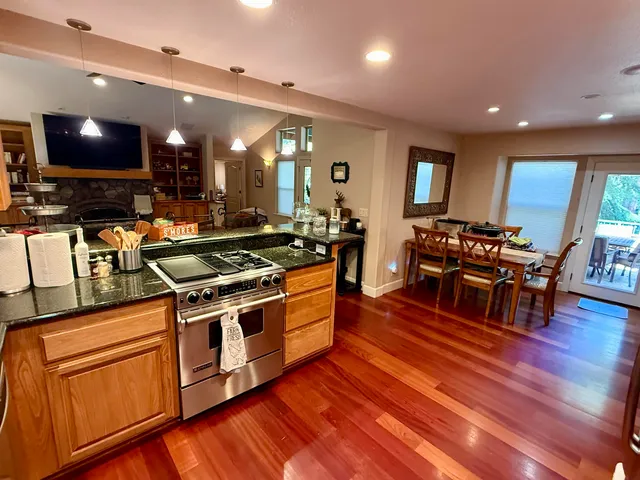 a kitchen with stainless steel appliances granite countertop a stove and a wooden floors