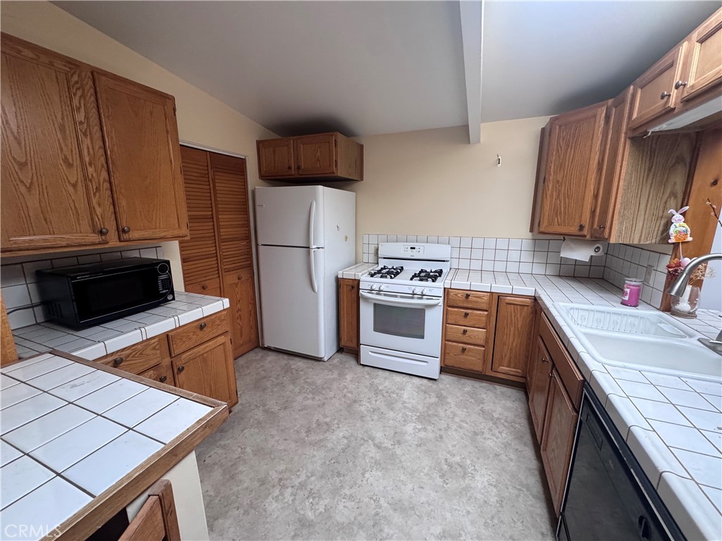 19509 Stagg Street Reseda, CA 91335 - Photo 5 of 9 a kitchen with stainless steel appliances kitchen island granite countertop a stove a sink and a refrigerator