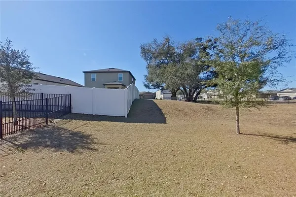 a view of yellow house with large trees