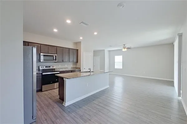 a kitchen with stainless steel appliances granite countertop a sink a refrigerator and a granite counter tops
