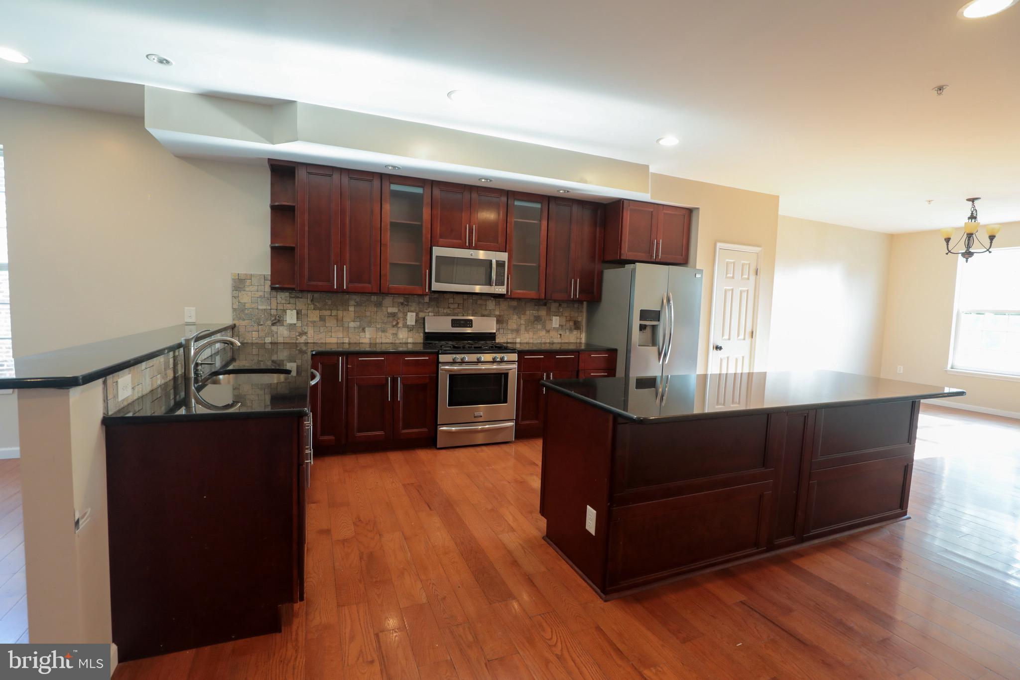 a kitchen with stainless steel appliances wooden floors and wooden cabinets
