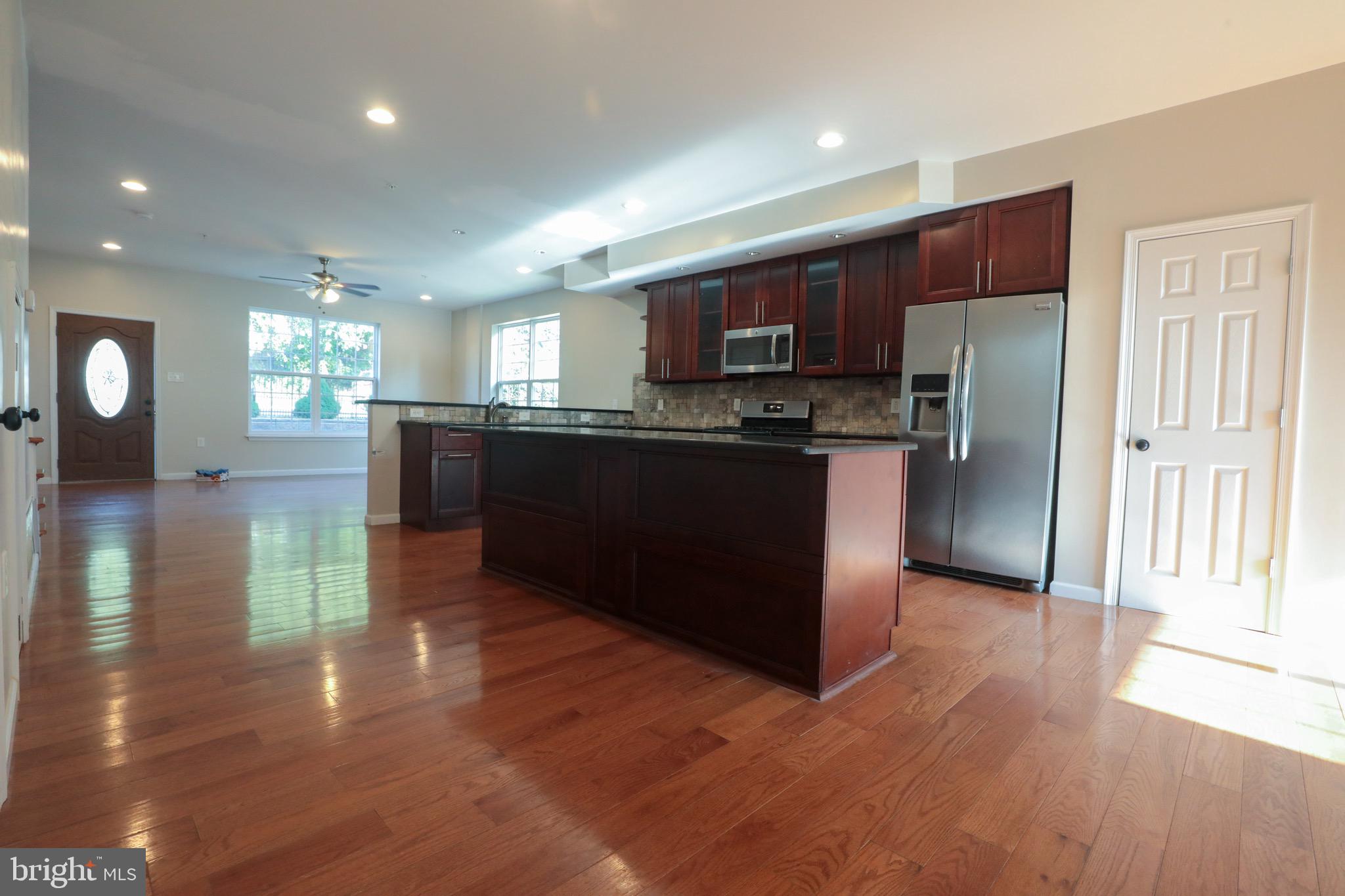 4779 Manayunk Avenue Philadelphia, PA 19128 - Photo 5 of 17 a kitchen with stainless steel appliances granite countertop a refrigerator a sink dishwasher a stove and a refrigerator with wooden floor