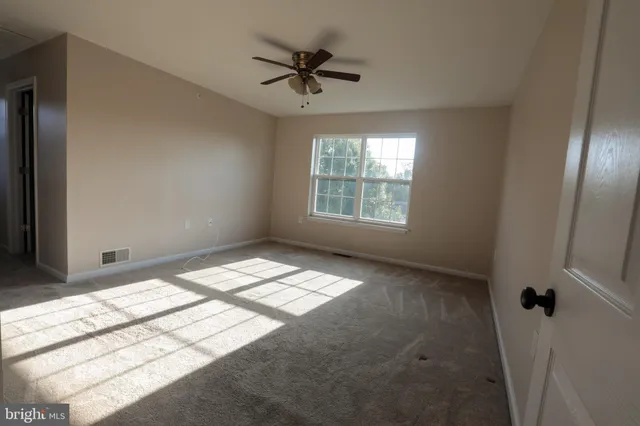 a view of room with a ceiling fan and window