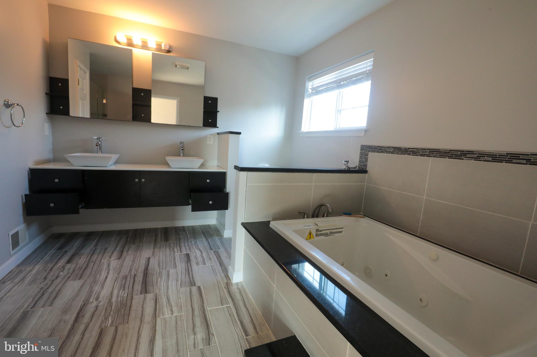 4779 Manayunk Avenue Philadelphia, PA 19128 - Photo 9 of 17 a bathroom with a sink a large mirror and vanity