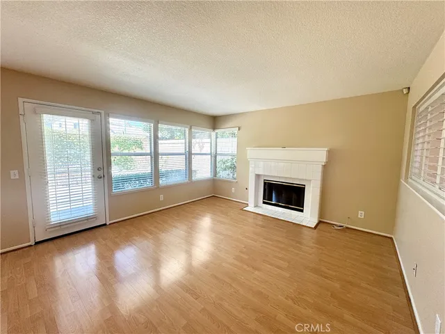 a view of empty room with wooden floor and fireplace