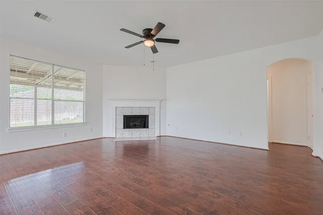 a view of an empty room with a fireplace and a window