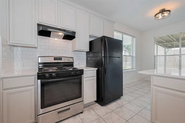 a kitchen with granite countertop white cabinets and white appliances
