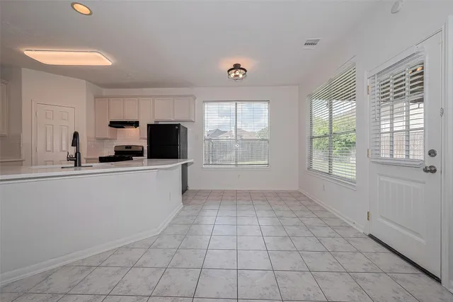 a kitchen with a sink a stove top oven and cabinets
