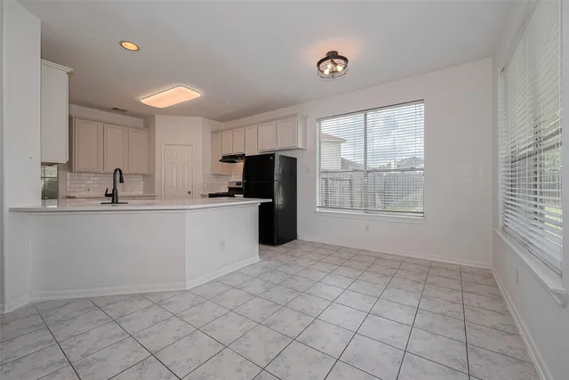 a kitchen with a refrigerator a stove top oven and a window