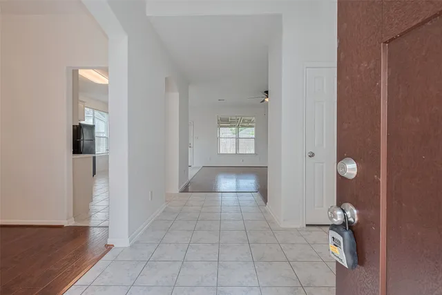 an empty room with windows and ceiling fan