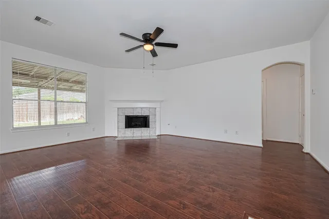 a view of an empty room with window and wooden floor