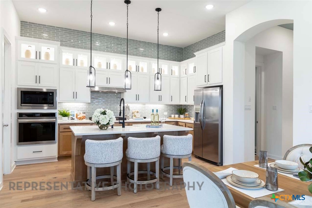 508 High Summit Drive Georgetown, TX 78628 - Photo 13 of 39 a kitchen with stainless steel appliances granite countertop a sink a stove a refrigerator and island with wooden floor