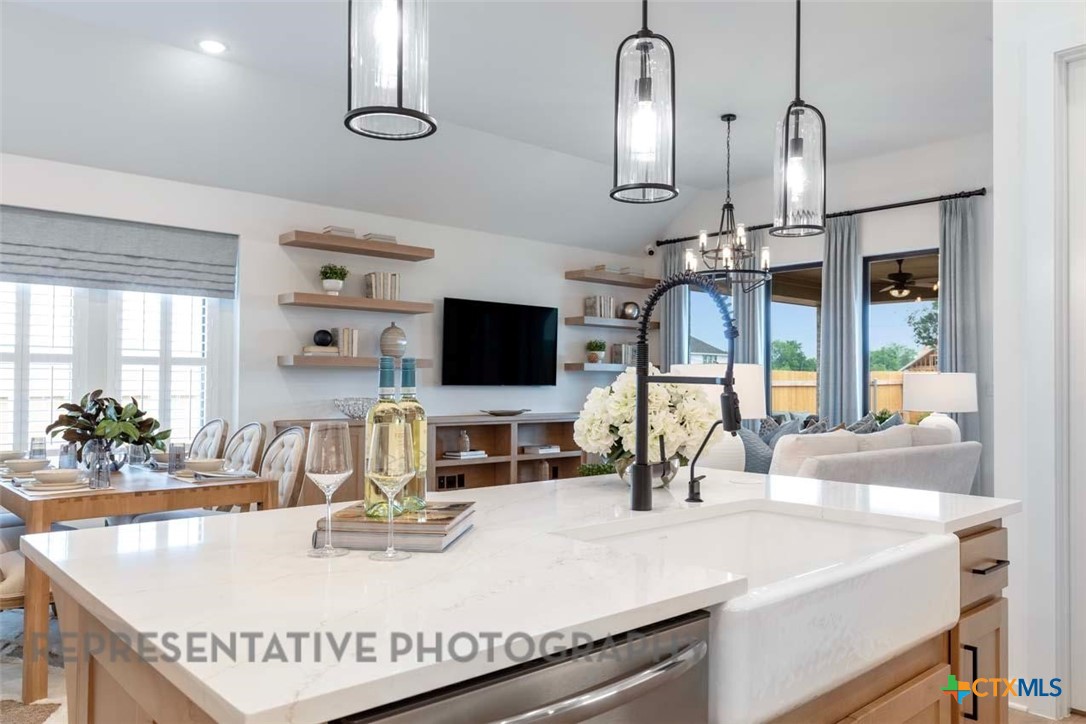 508 High Summit Drive Georgetown, TX 78628 - Photo 10 of 39 a view of kitchen island with granite countertop a sink a stove and a wooden floor