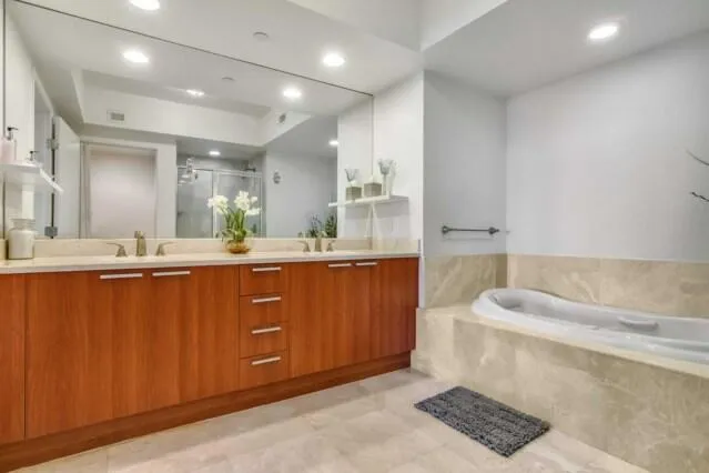 a bathroom with a tub sink and mirror