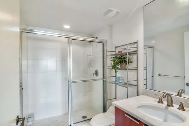 a bathroom with a shower sink mirror and toilet