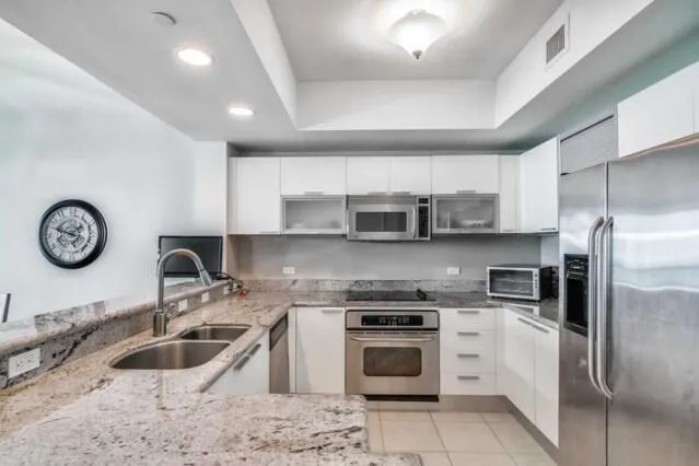 a kitchen with stainless steel appliances granite countertop a sink stove oven and refrigerator