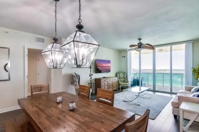 a living room with furniture a flat screen tv and a floor to ceiling window