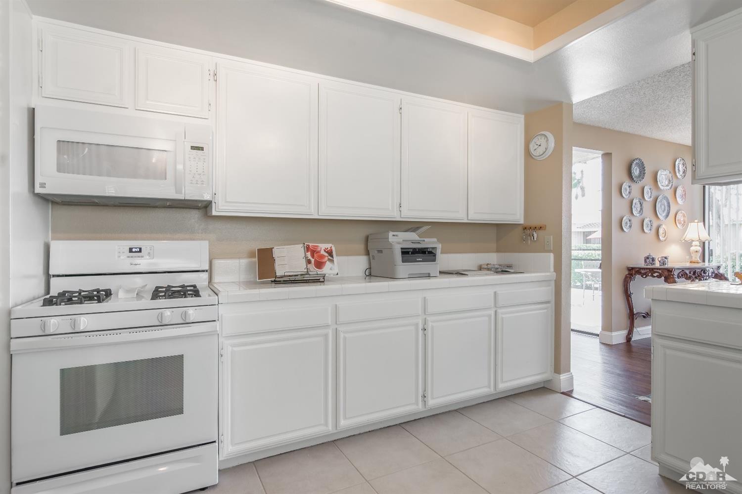 72475 Rodeo Way, Unit 320 Rancho Mirage, CA 92270 - Photo 4 of 26 a kitchen with granite countertop white cabinets and white appliances