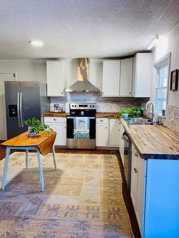 a kitchen with stainless steel appliances granite countertop a stove top oven and cabinets