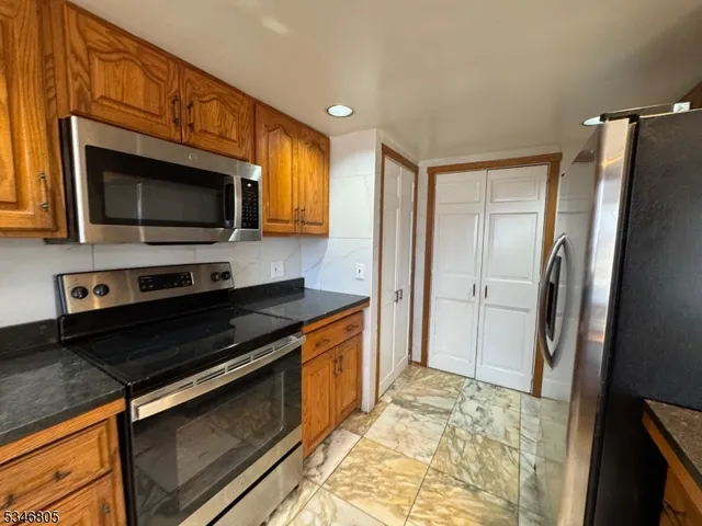 a kitchen with stainless steel appliances a stove microwave and refrigerator
