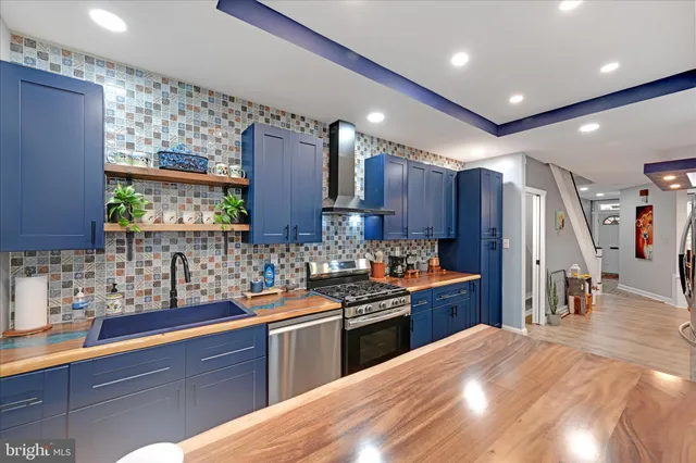 a kitchen with stainless steel appliances kitchen island granite countertop a sink stove and refrigerator