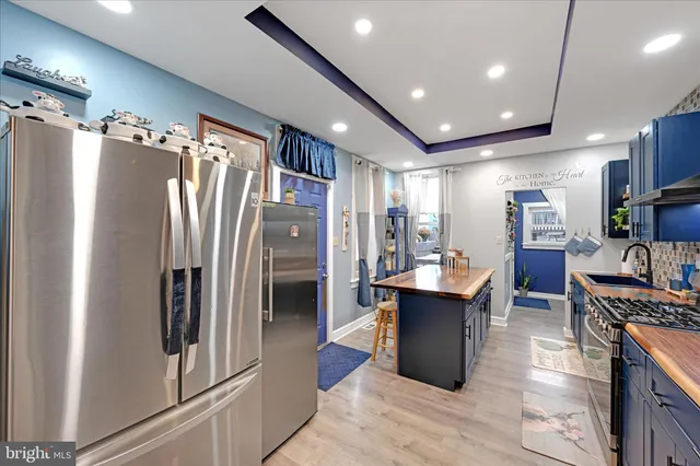 a kitchen with stainless steel appliances granite countertop a refrigerator and a stove