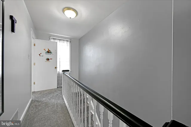 a view of a hallway with wooden floor and stairs
