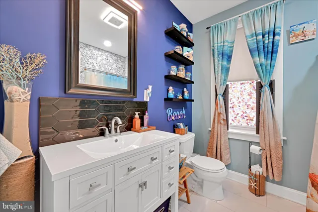 a bathroom with a sink a toilet and a window