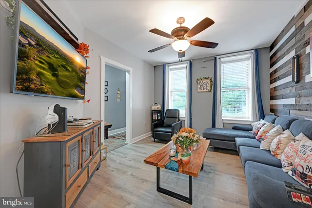 a living room with furniture a window and a flat screen tv