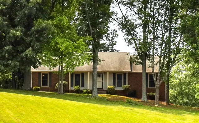 a front view of house with yard and swimming pool