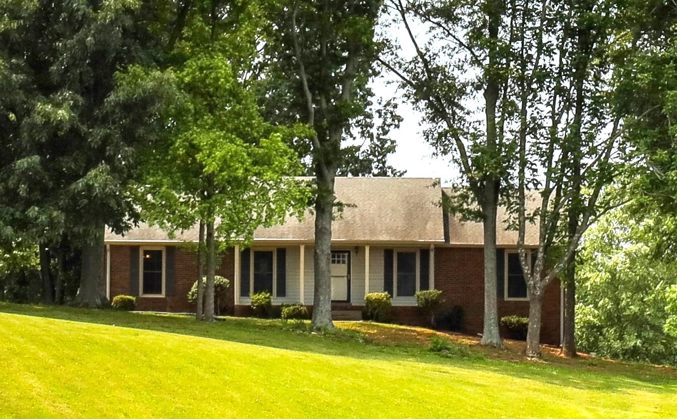 a front view of house with yard and swimming pool