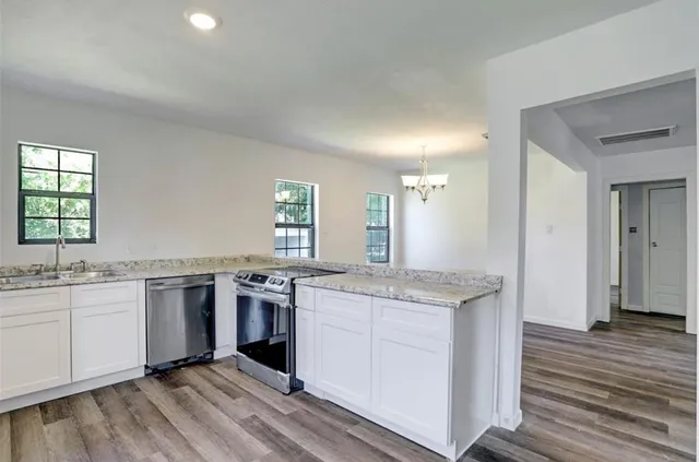 a kitchen with stainless steel appliances granite countertop hardwood a sink stove and refrigerator