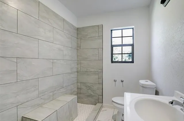 a bathroom with a toilet sink and shower