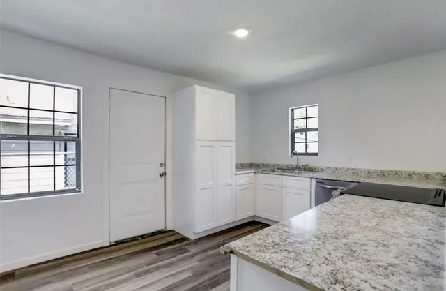 a kitchen with a stove a sink and a window