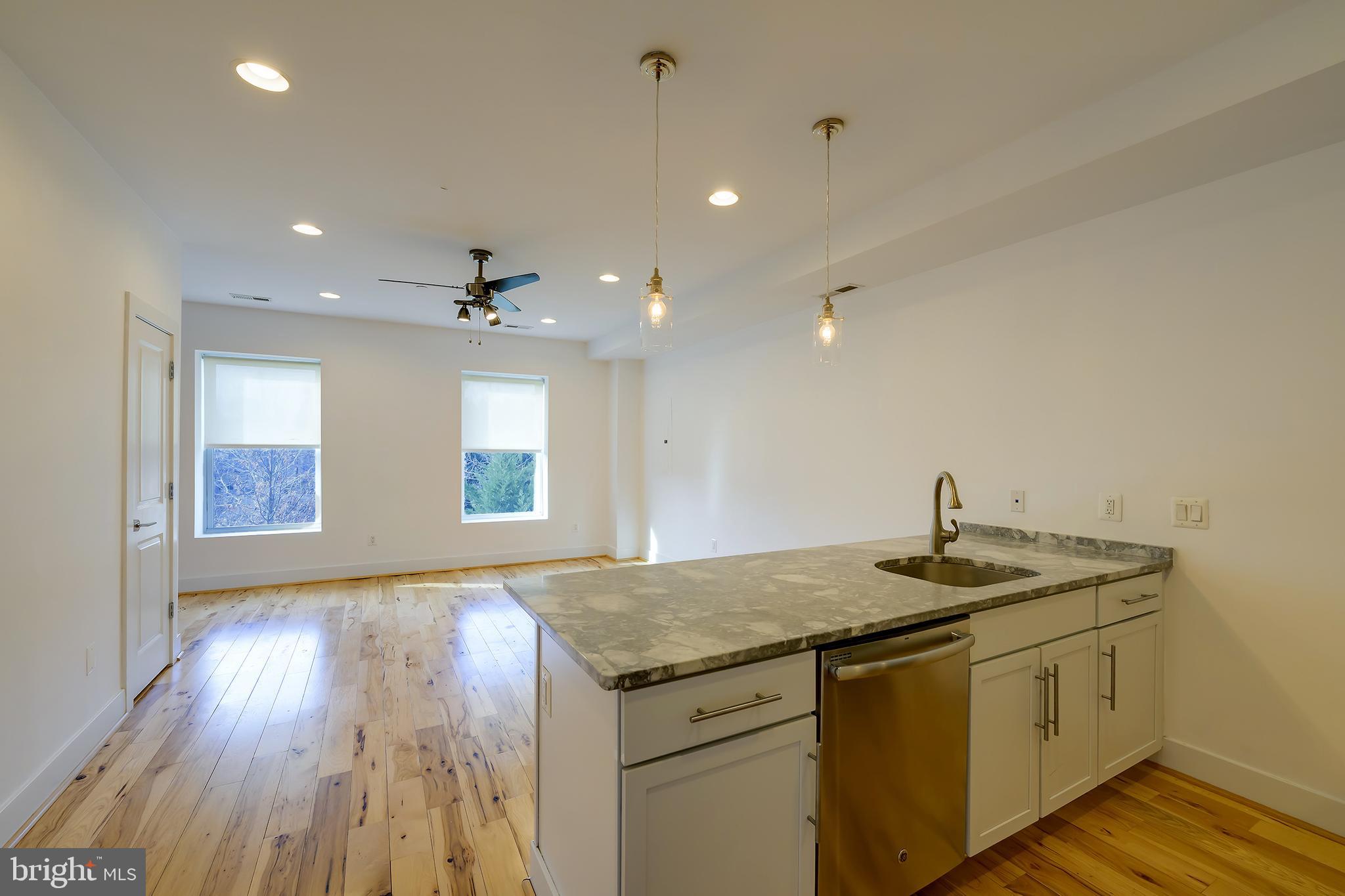 3325 11th Street Northwest, Unit 5 Washington, DC 20010 - Photo 4 of 25 a kitchen with kitchen island granite countertop a sink and a stove
