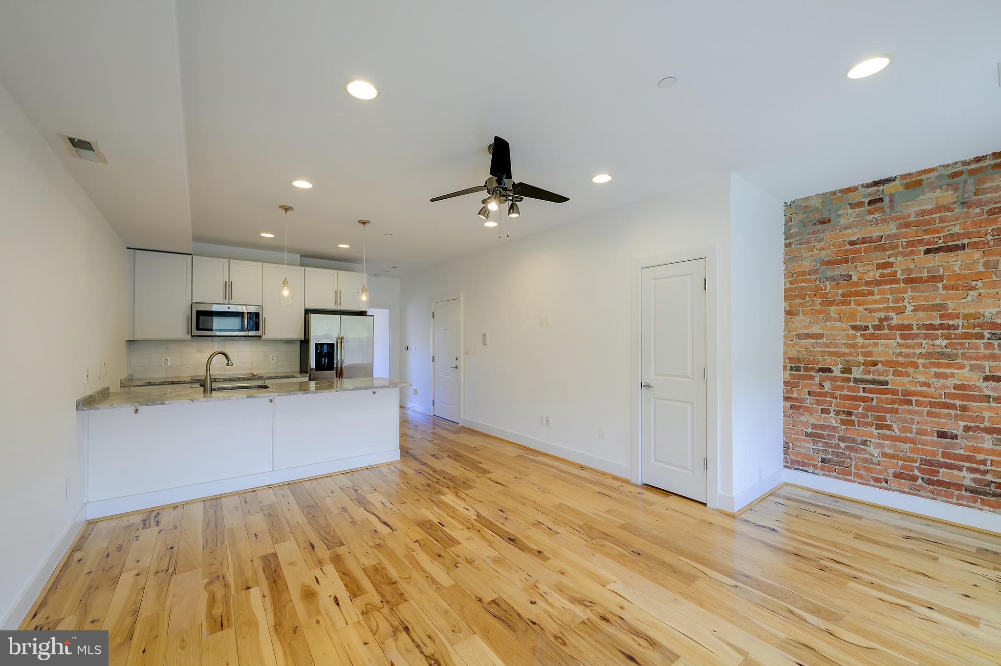 3325 11th Street Northwest, Unit 5 Washington, DC 20010 - Photo 7 of 25 a view of a kitchen with kitchen island wooden floor center island and stainless steel appliances