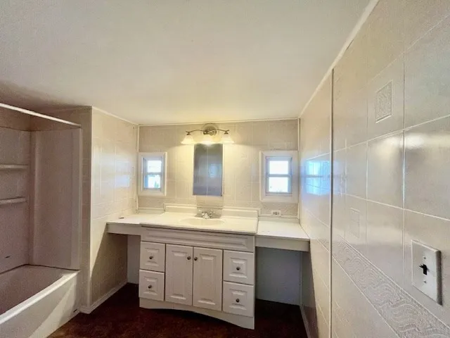 a bathroom with a double vanity sink and mirror with shower