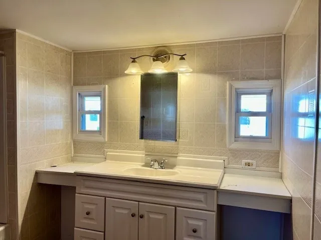 a bathroom with a sink and two mirror