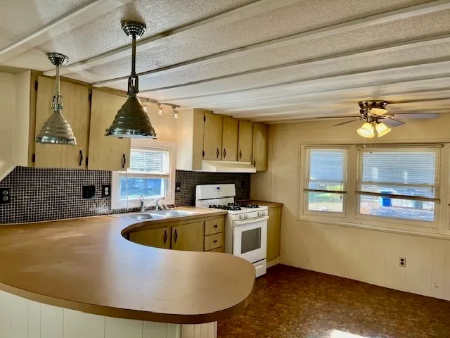 a view of a kitchen with a sink a microwave and cabinets