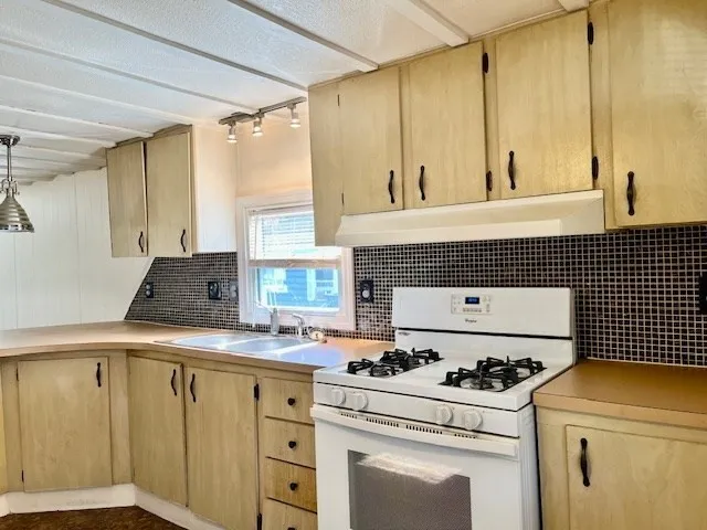 a kitchen with a stove a sink and a refrigerator