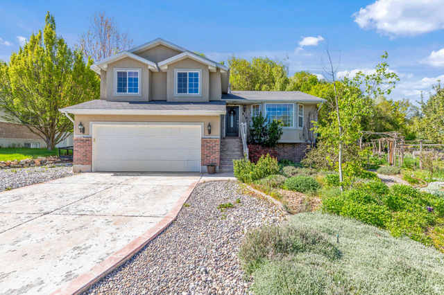 Two-story stucco and brick residence featuring a two-car garage and a bay window