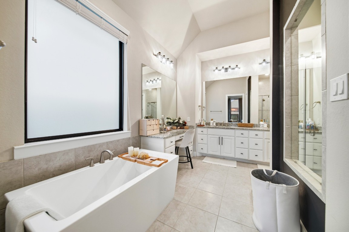 8902 Iron Forge Road Missouri City, TX 77459 - Photo 23 of 44 a bathroom with a bathtub a sink and a mirror
