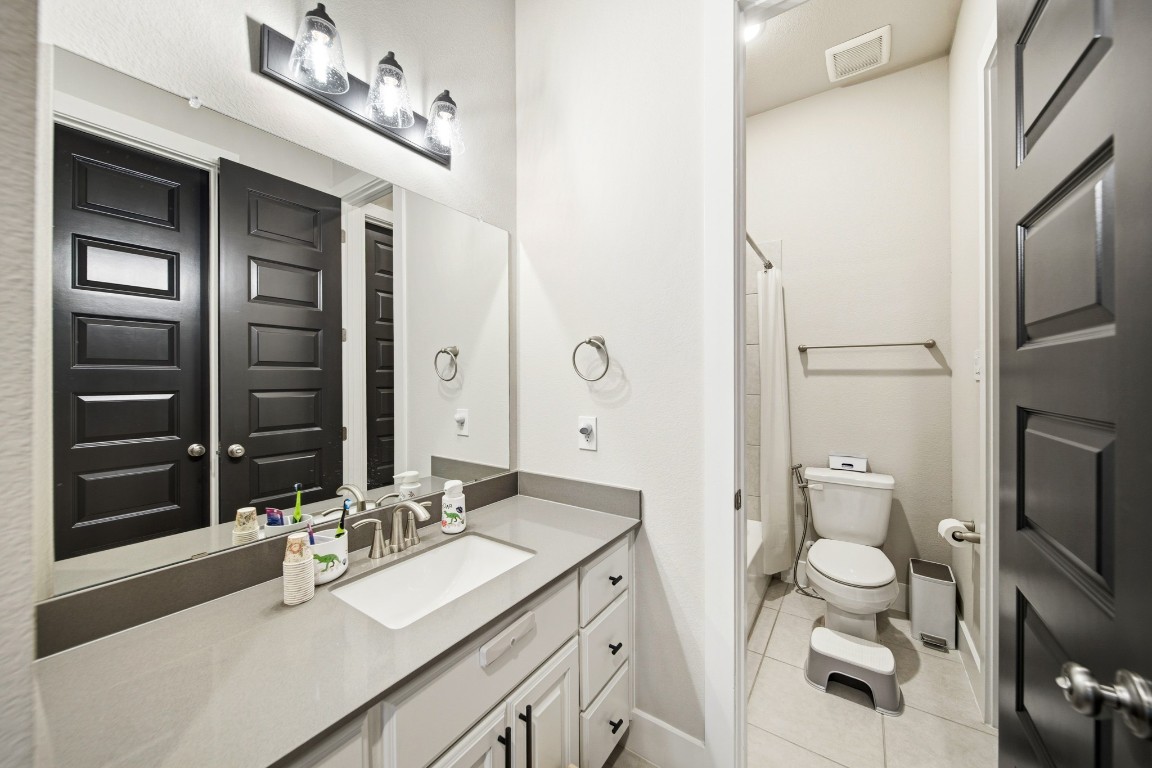 8902 Iron Forge Road Missouri City, TX 77459 - Photo 32 of 44 a bathroom with a granite countertop sink toilet and shower