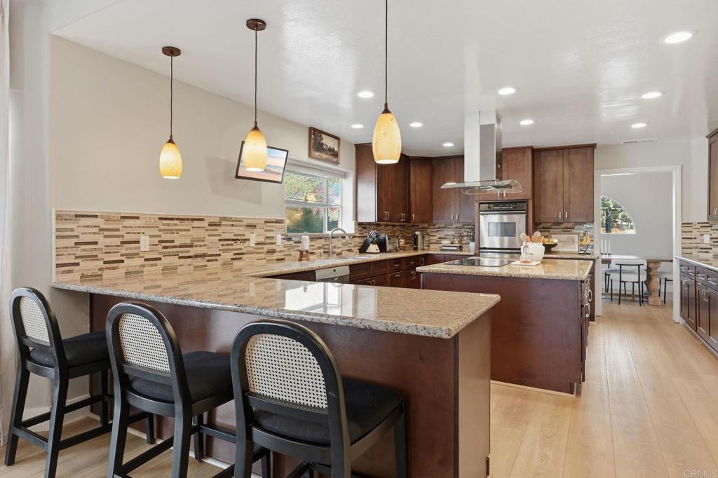2852 Conestoga Court Alpine, CA 91901 - Photo 15 of 65 a kitchen with stainless steel appliances granite countertop a stove a sink a microwave a dining table and chairs