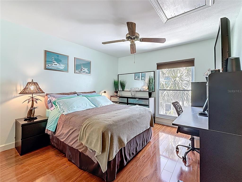 230 Medallion Boulevard, Unit G Madeira Beach, FL 33708 - Photo 22 of 38 a bedroom with a bed and wooden floor