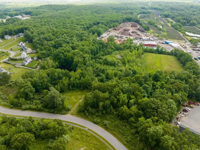 an aerial view of residential houses with outdoor space and trees