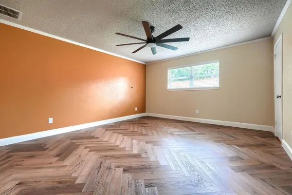 an empty room with wooden floor and windows