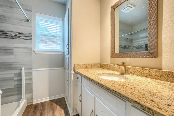 a bathroom with a granite countertop sink and a mirror