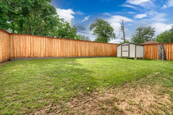 a view of a backyard with wooden fence